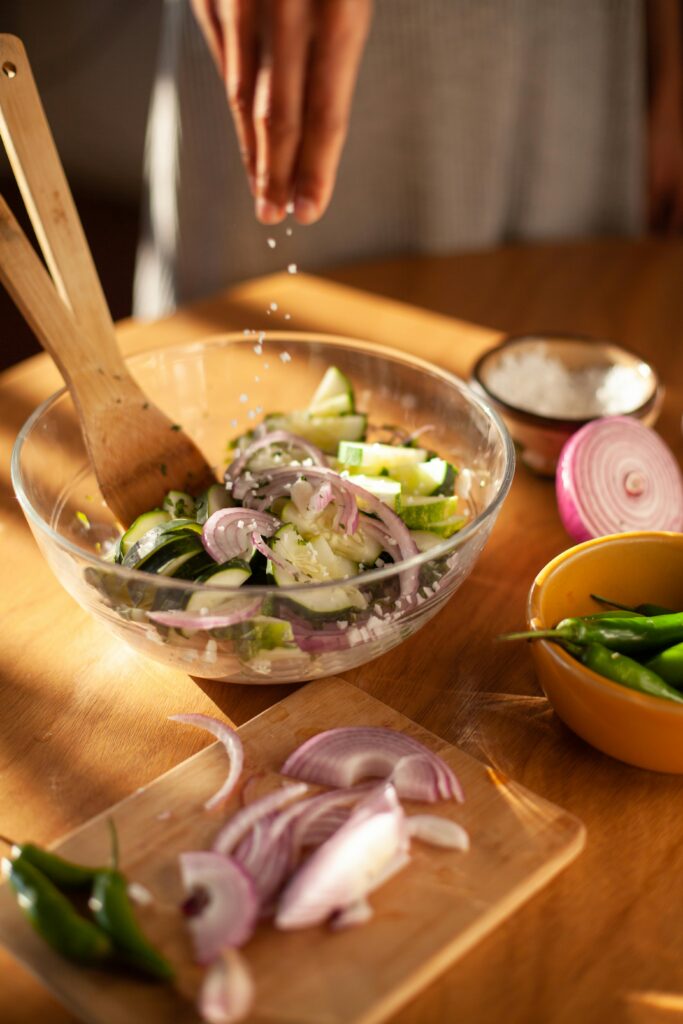A Person Putting Salt on Salad